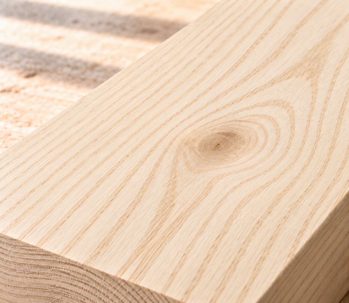 Close-up of solid ash board showing distinctive grain, a natural knot and light beige wood tone