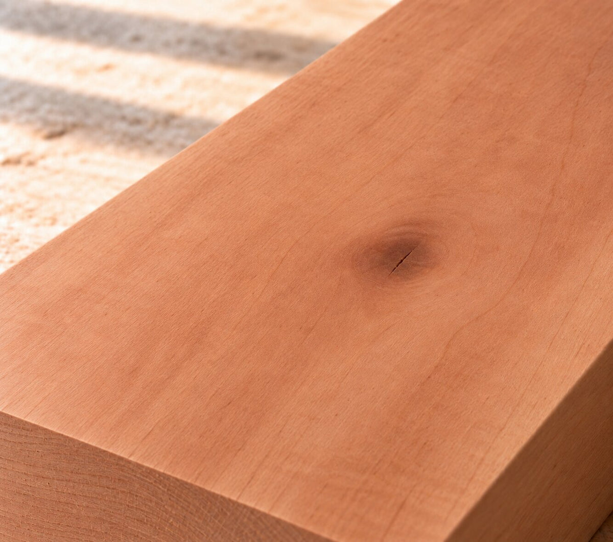 Close-up of solid pear wood showing fine grain and warm pink to reddish-brown colour