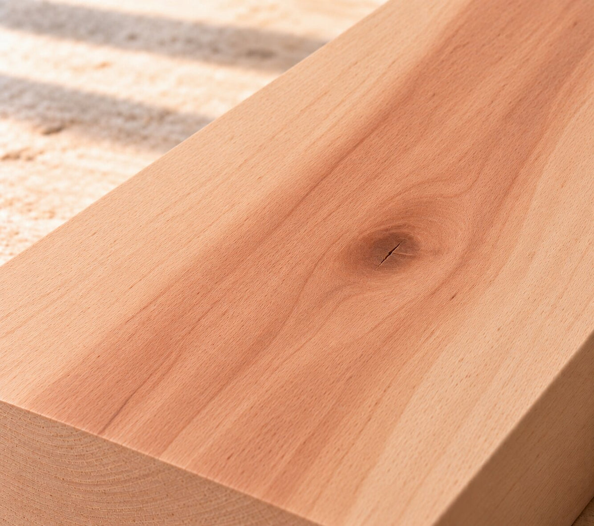 Close-up of solid red heart beech board showing fine grain, natural heartwood variation and a knot
